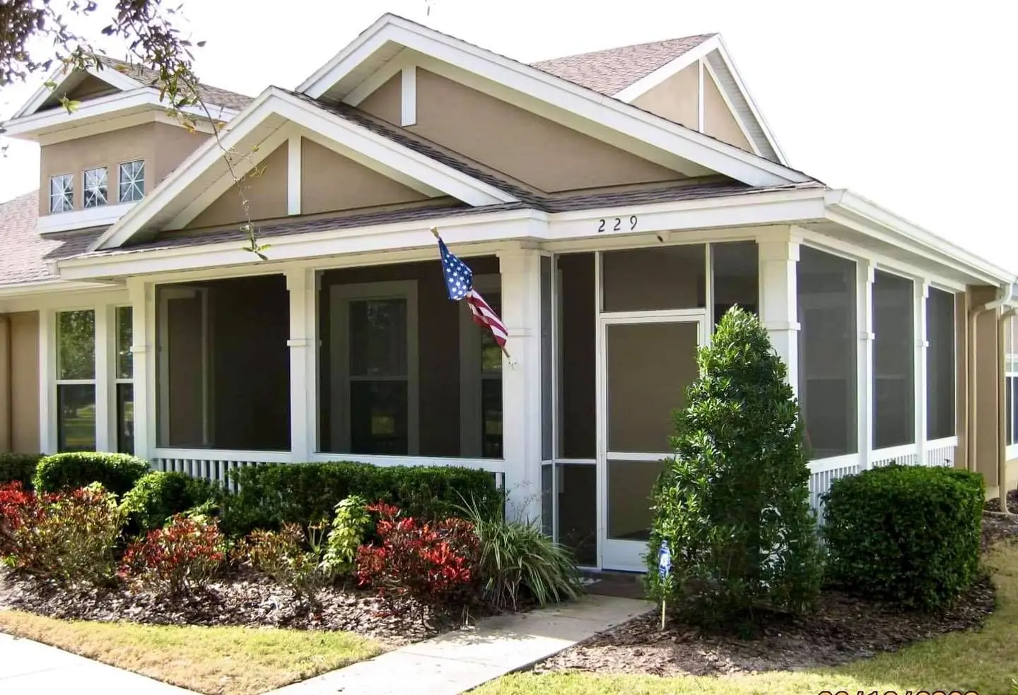 A house with a flag hanging from the front porch.