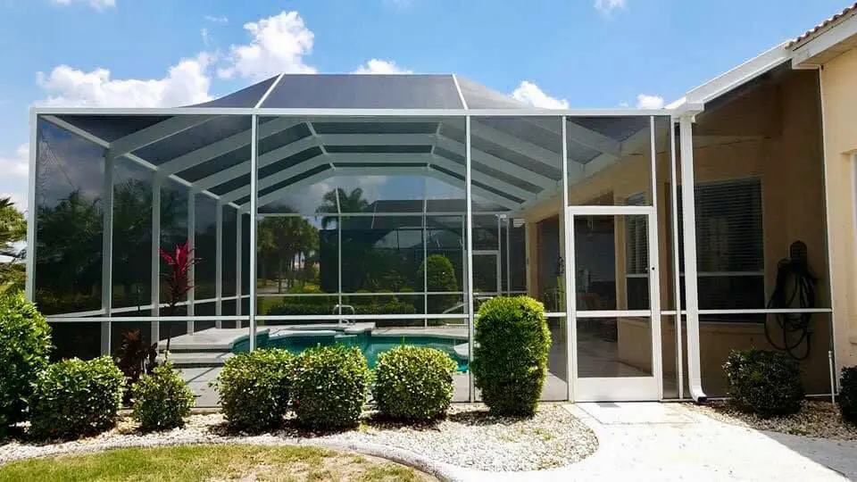 A pool enclosure with a large glass wall.